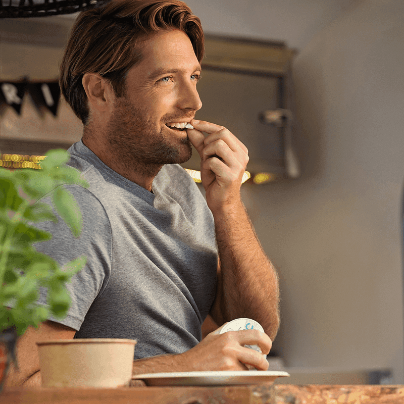 Lifestyle shot a man tucking a Nicotine Pouch under his lip.